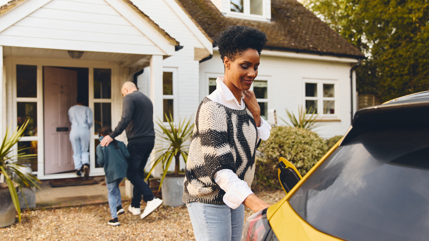 A woman standing in front of a yellow car